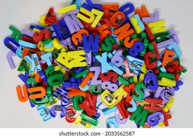 Pile Of Colourful Magnetic Board Letters And Numbers On White Background