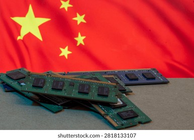 A pile of computer RAM memory sticks and electronic components set against the blurred flag of China, representing technology production, the semiconductor industry, and manufacturing in China