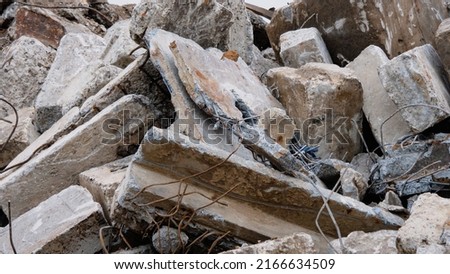 A pile of concrete debris from a building. Destroyed cement building. Concrete fragments of the building close-up. Explosion or demolition of buildings. Construction debris