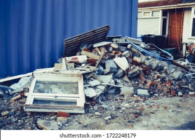 A Pile Of Construction Waste Near Private House. Building Rubble, Bricks, Stones. Junk, Garbage Piled Up Near The Building. Street Scene. Recycling Industry, Rubbish Removal And Collection Service