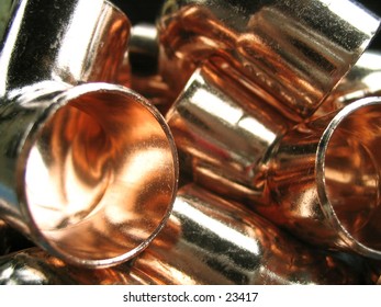 a pile of copper tubing elbows used in construction