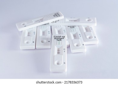 Pile Of Coronavirus Antigen Tests, With Positive And Negative Results, On White Background