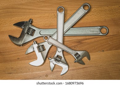Pile Of Crescent Wrenches On Wood Work Bench Overhead View