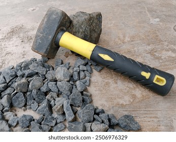 A pile of crushed concrete with a sledgehammer lying on it - Powered by Shutterstock