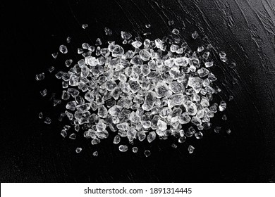 Pile of crushed ice cubes on black stone background, top view with copy space
