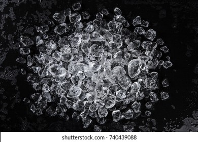 Pile of crushed ice on a black table. Top view