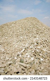 Pile Of Crushed Stone. Road Gravel, Gravel Texture. Small Rubble On A Background Of Blue Sky