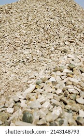 Pile Of Crushed Stone. Road Gravel, Gravel Texture. Small Rubble On A Background Of Blue Sky