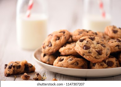 Pile of Delicious Chocolate Chip Cookies on a White Plate with Milk Bottles - Powered by Shutterstock