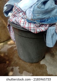 Pile Of Dirty Clothes In Black Bucket.