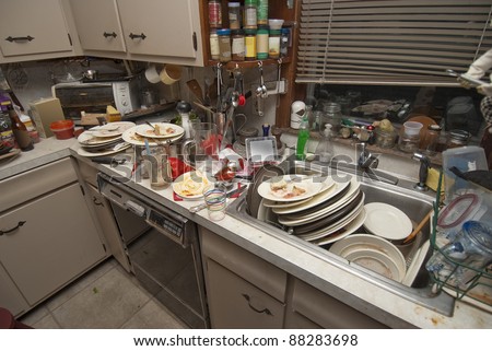 Pile of dirty dishes in sink and counter top after a party