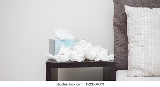 A Pile Of Dirty, Used, And Crumpled Up Tissues On A Nightstand.