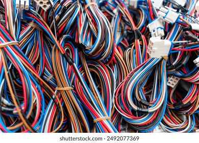 a pile of discarded electrical wires and cords in blue, white, brown and red.	