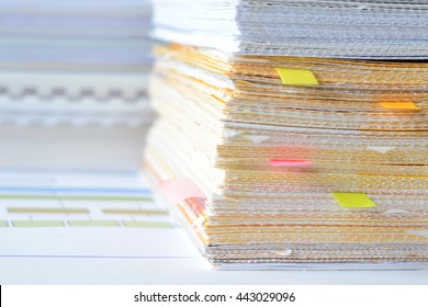 Pile of documents at business office with high key tone,financial statements,financial reports with sticky notes.