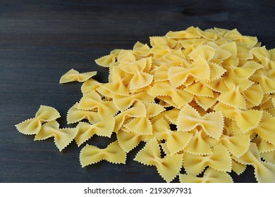 Pile of Dried Farfalle or Bow-tie Pasta on Black Wooden Background - Powered by Shutterstock