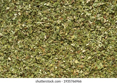 Pile of dried green oregano texture or background close-up macro shot.