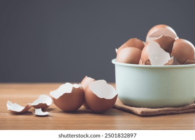 A pile of eggshells sits on a table against a gray background, symbolizing the potential benefits of eggshells in sustainability, from gardening and composting to household uses.