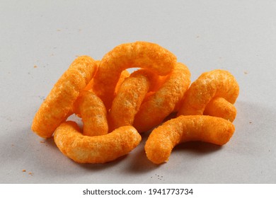 Pile Of Extruded Cheese Puffs Isolated On White.