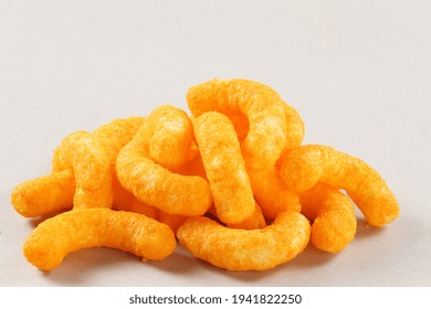 Pile Of Extruded Cheese Puffs Isolated On White.