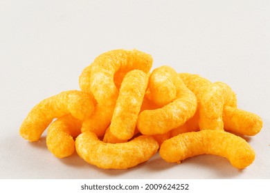 Pile Of Extruded Cheese Puffs Isolated On White.
