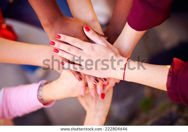 pile of female multiracial hands in union sign