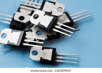 Pile of field-effect transistors on blue surface background. Selective focus