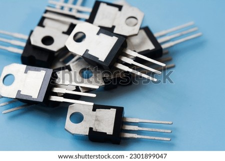 Pile of field-effect transistors on blue surface background. Selective focus