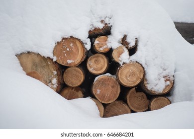 A Pile Of Firewood Buried Under A Mound Of Snow. 