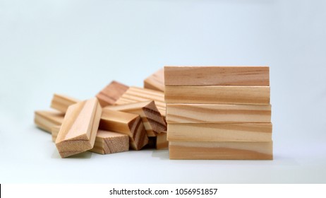 A Pile Of Five Wooden Blocks In Front Of Stacked Blocks Of Wood.