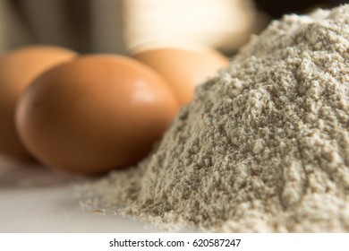 Pile of flour with eggs in background
