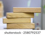 A pile of four wooden blocks on the soft white background.