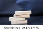 A pile of four wooden blocks on the soft black background.