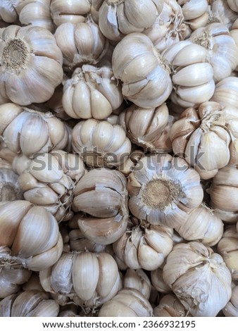 A pile of fresh garlic bulbs neatly displayed at the supermarket, enticing with their pungent aroma and culinary potential