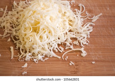 Pile Of Fresh Grated Cheese On Wooden Table