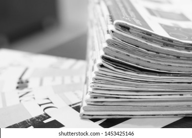 Pile of fresh morning newspapers on the table at office. Latest financial and business news in daily paper. Pages with information (headlines, articles, photos, text). Folded and stacked journals      - Shutterstock ID 1453425146