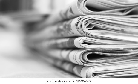 Pile of fresh morning newspapers on the table at office. Latest financial and business news in daily paper. Pages with information (headlines, articles, photos, text). Folded and stacked journals - Shutterstock ID 786606589