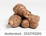 Pile of freshly harvested Jerusalem artichokes, also called topinambur, unpeeled skin, placed on white background