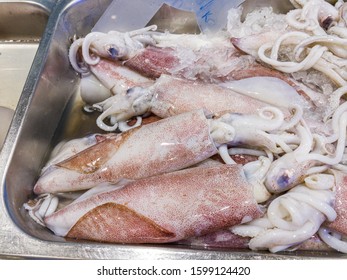 Pile Of Frozen Squids For Sale At Seafood Market