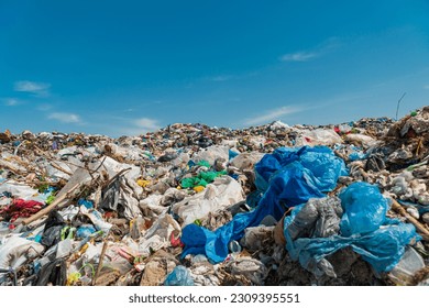 A pile of garbage in a landfill against a blue sky. - Shutterstock ID 2309395551