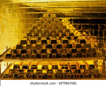 A pile of gold bars in front of a golden wall; golden ingots