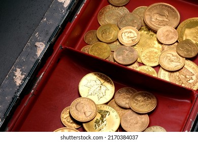 A Pile Of Gold Coins In An Open Cash Box