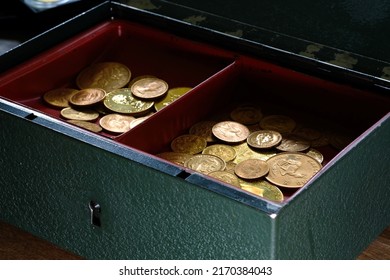 A Pile Of Gold Coins In An Open Cash Box