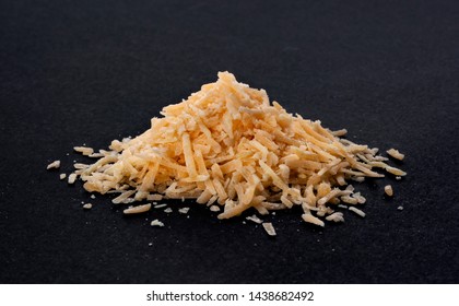 Pile Of Grated Parmesan Cheese On Black Background