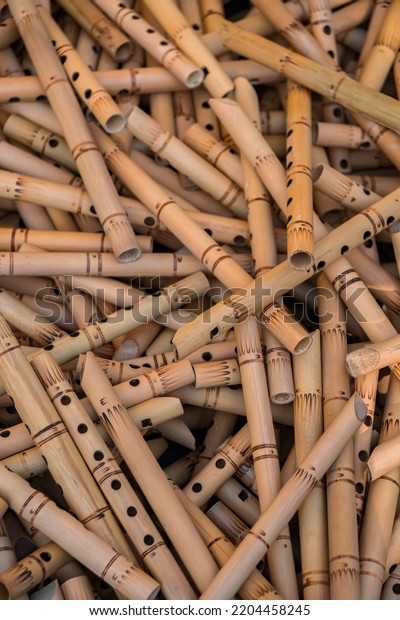 Pile of half-finished bamboo flutes,\
handmade bamboo flute production process by craftsmen, bamboo\
flutes being dried before finishing and\
marketed