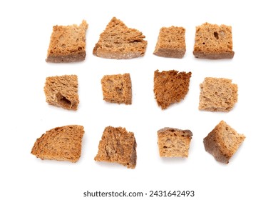 Pile of homemade bread croutons isolated on white background, top view. Crispy bread cubes, dry rye crumbs, crackers, croutons or white toasted crackers.