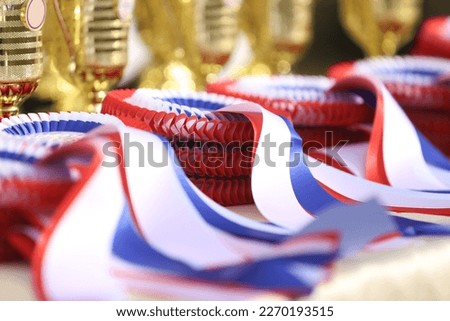 Pile of horse sport trophies rosettes at equestrian event at summertime outdoors