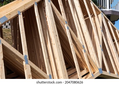 A Pile Of House Rafters Waiting On The Ground