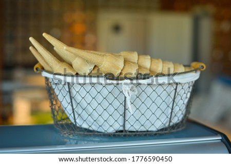 Pile of ice cream cones in the basket background .