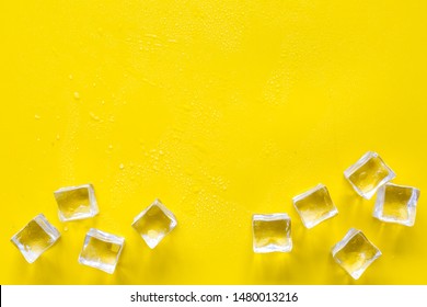 Pile of ice cubes on yellow bar desk background top view mock-up