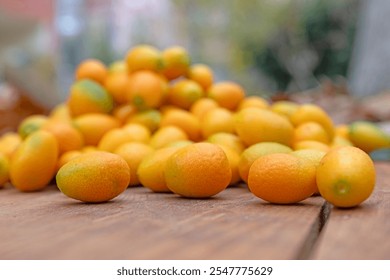 A pile of kumquat fruit on a wooden floor. - Powered by Shutterstock